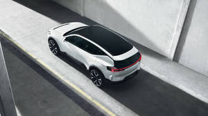 白色電動SUV，黑色車頂，停在混凝土坡道上。 — 富豪 壁紙