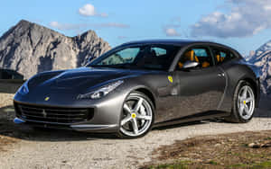 磨砂灰色法拉利 GTC4Lusso 停泊在山間碎石路上，後面是岩石山峰。 — Steam Deck OLED 壁紙