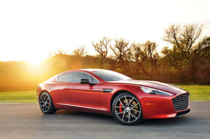 紅色Aston Martin跑車在金色日落時停放在道路上。 — 奧斯頓馬丁 壁紙