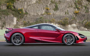 紅色McLaren 720S跑車在賽道上，靠近岩石懸崖。 — 跑車 壁紙
