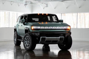 綠色Hummer EV SUV在明亮的白色工作室中，地板具有反射效果。 — 卡車 壁紙
