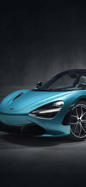 工作室中帶有戲劇性照明的藍綠色McLaren跑車。 — iPhone 16 Pro Max 壁紙