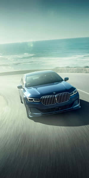 藍色BMW轎車在海岸公路上飛馳，伴隨著海浪和日落天空。 — Mercedes Benz C300 壁紙