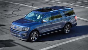 藍色福特 Expedition SUV 停在龜裂的瀝青停車場上。 — 福特 壁紙