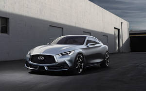 銀色 Infiniti 跑車停放在白色磚砌建築前。 — Infiniti 壁紙