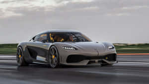 銀色 Koenigsegg Jesko 在潮濕的賽道上飛馳，帶有黃色點綴。 — 跑車 壁紙