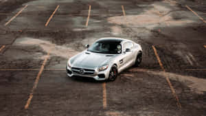 銀色 Mercedes-AMG GT 跑車停放在一個風化的停車場。 — Mercedes Benz C300 壁紙