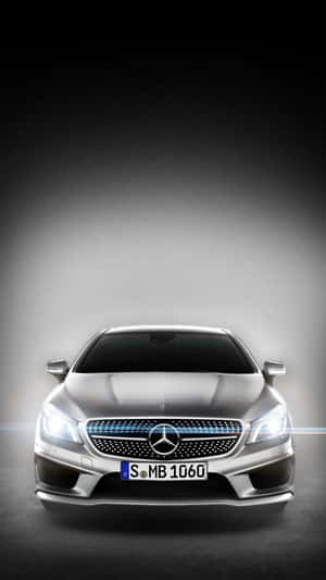 銀色 Mercedes-Benz CLA 的前視圖，頭燈亮起，格柵帶有藍色點綴。 — Mercedes Benz C300 壁紙