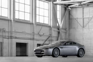 大型工業倉庫內的銀色Aston Martin Vanquish跑車。 — Surface Pro 壁紙