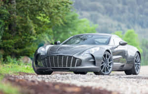 森林環境中碎石路上的銀色Aston Martin — MacBook Air M4 壁紙