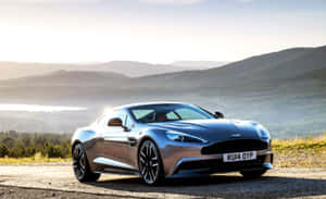 日出時分，一輛銀色Aston Martin跑車停在風景優美的山路上。 — 阿斯頓維拉 壁紙