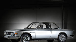 在黑暗工作室中，聚光燈下的銀色經典BMW 3.0 CSL跑車。 — Mercedes Benz C300 壁紙