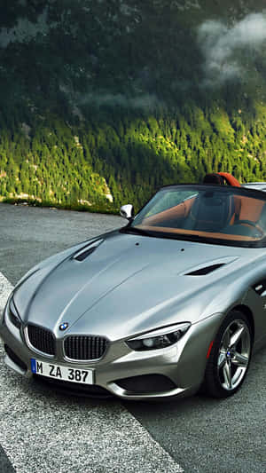 銀色BMW Z8敞篷跑車停泊在山路上，有森林和霧氣山峰。 — 三星Galaxy 壁紙