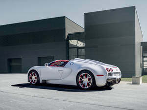 銀色Bugatti Veyron配紅色內飾，停在現代建築前。 — 白色 iPhone 壁紙