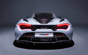 銀色McLaren 720S跑車後視圖，帶紅色尾燈，在攝影棚中。 — 4K 法拉利 壁紙