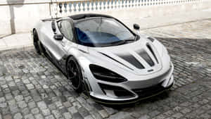 銀色McLaren跑車停在石牆附近的鵝卵石街道上。 — 4K 法拉利 壁紙