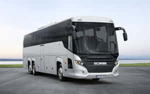 銀色Scania長途巴士在暮色中停靠水邊。 — 釜山 壁紙