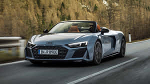 銀色奧迪R8 Spyder敞篷跑車在秋樹山路上疾馳。 — 奧迪 GIF 壁紙