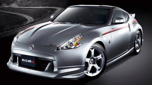 銀色日產350Z Nismo跑車在黑暗蜿蜒的道路上帶有紅色條紋。 — 跑車 壁紙