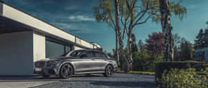 銀色賓士S-Class停在現代房屋前，周圍有樹木和碎石。 — Mercedes Benz C300 壁紙