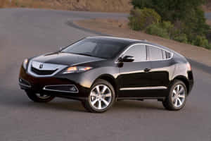 黑色Acura SUV在日落時分行駛在蜿蜒的道路上，穿過乾燥的景觀。 — Acura 壁紙
