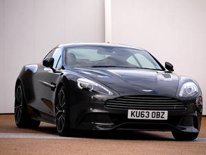 黑色Aston Martin跑車停在白色牆壁前。 — 奧斯頓馬丁 壁紙