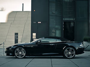 黑色Aston Martin敞篷車停放在現代建築前 — 奧斯頓馬丁 壁紙