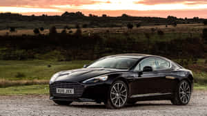 黑色Aston Martin停在夕陽下的碎石地上 — 奧斯頓馬丁 壁紙