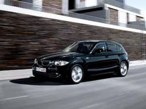 黑色BMW 1系列掀背車在模糊背景的城市道路上疾馳。 — Mercedes Benz C300 壁紙