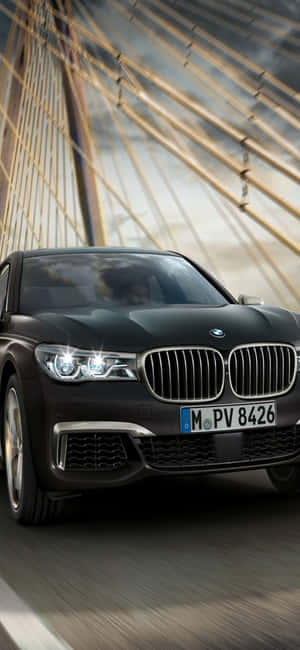 黑色BMW 7系列在現代懸索橋上疾馳。 — Infinix Note 壁紙