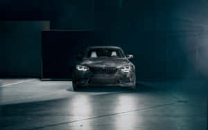 黑色BMW M2跑車在昏暗車庫中被聚光燈照亮，伴有薄霧。 — 福斯汽車 壁紙