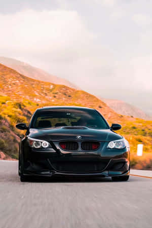 黑色BMW M3在夕陽下的山路疾馳 — Huawei MatePad 11.5 (2025) 壁紙