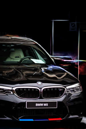 黑色BMW M5跑車，霓虹燈在其閃亮表面上反射。 — 三星Galaxy 壁紙