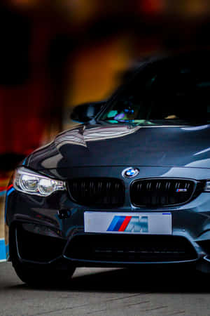 夜晚街道上黑色BMW M汽車，車頭燈亮起。 — Huawei MatePad 壁紙