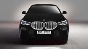 黑色BMW SUV正面視圖，在工作室環境中帶有照明頭燈和鍍鉻格柵。 — 最佳黑暗 壁紙