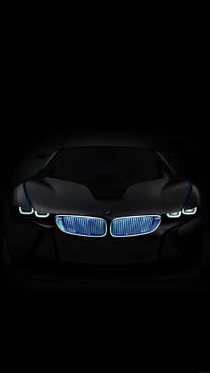 黑色BMW概念車在黑暗中亮起藍色車頭燈的正面視圖。 — BMW iPhone 壁紙