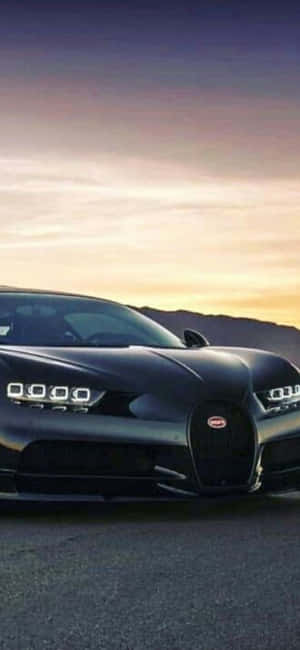 黑色Bugatti Chiron在開闊道路上的日落時分 — Galaxy A15 壁紙