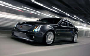黑色Cadillac CTS-V在照明隧道中疾馳，帶有動態模糊效果。 — 凱迪拉克 壁紙
