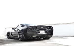 黑色Corvette跑車停放在簡約的車庫環境中。