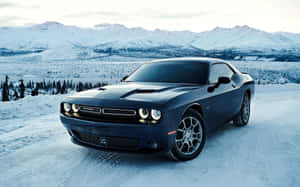 黑色Dodge Challenger在積雪道路上，背景有雪山。 — 汽車 壁紙