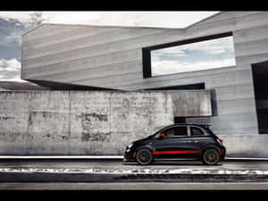 黑色Fiat 500帶有紅色條紋，停在現代混凝土建築前。 — 賽車 壁紙