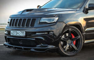 黑色Jeep Trackhawk配備紅色制動卡鉗，停在日落時分的瀝青路面上。 — 吉普 壁紙