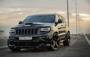 日落時分高速公路上帶紅色制動卡鉗的黑色Jeep Grand Cherokee SRT。 — 吉普 壁紙