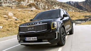黑色Kia Telluride SUV在岩石背景的山路上 — 起亞 壁紙