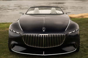 黑色Maybach敞篷車，白色內裝，停在近水的草地上。 — Surface Pro 壁紙