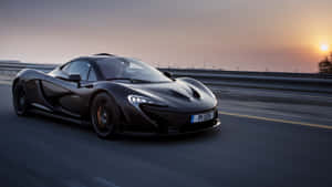 黑色McLaren P1在日落時分於高速公路上疾馳，帶有動態模糊效果。 — 麥拉倫 壁紙