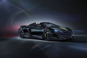 在黑暗的工作室環境中，黑色McLaren跑車帶有綠色亮點。 — 麥拉倫 壁紙