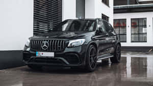 黑色Mercedes-AMG GLC 63 S SUV停在濕路面上，帶有建築物倒影。 — Mercedes Benz C300 壁紙