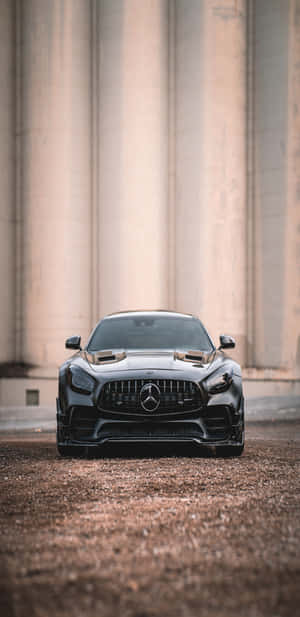 黑色Mercedes-AMG GT停在碎石上，前方混凝土柱。 — Mercedes Benz C300 壁紙