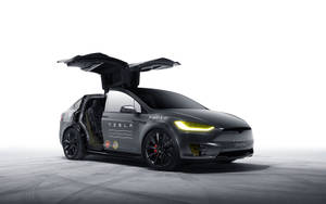 黑色Tesla Model X在攝影棚中打開車門並亮起車頭燈。 — 特斯拉 壁紙